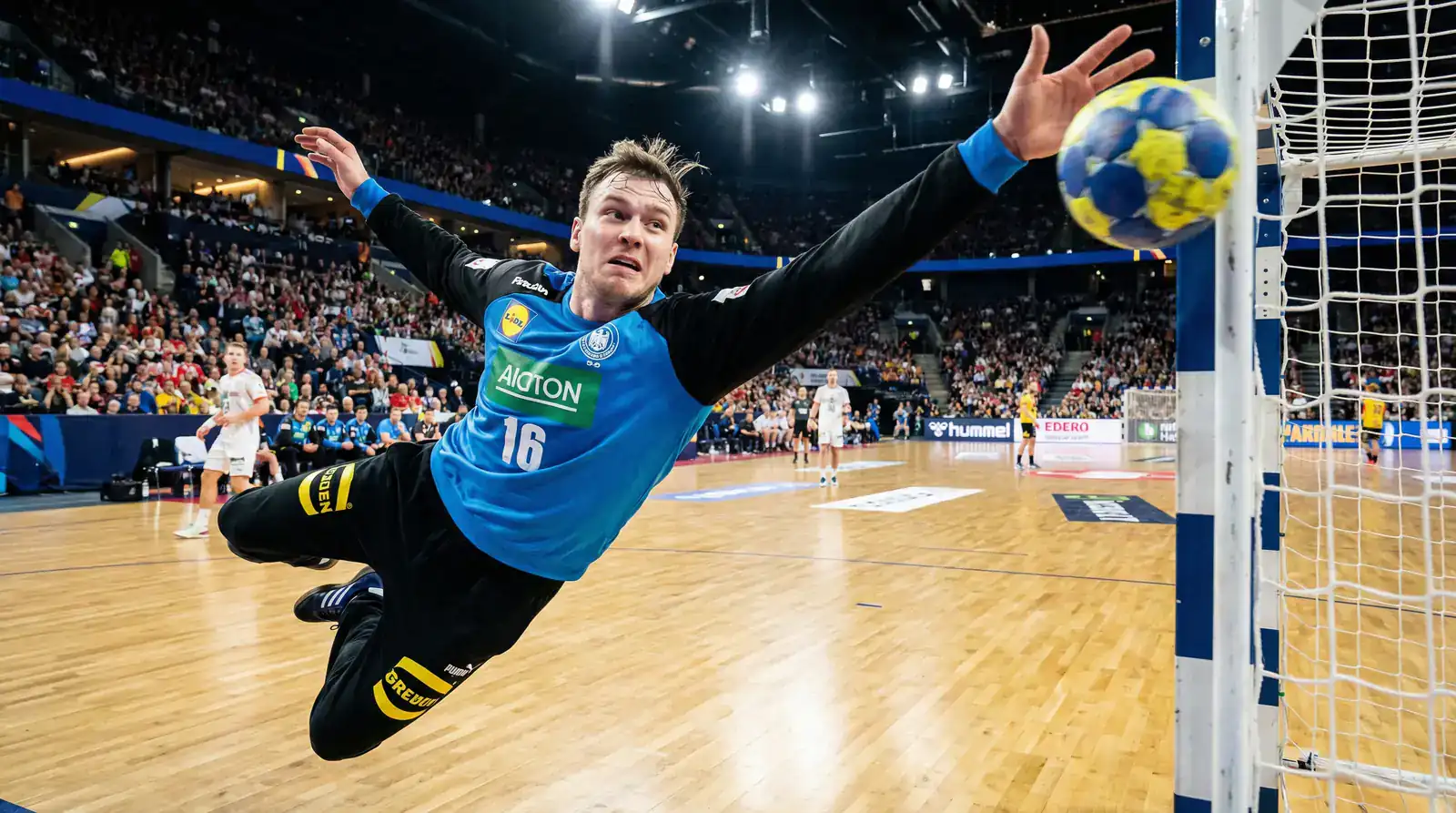 Gardien de handball realisant un arret spectaculaire lors d'un match de haut niveau
